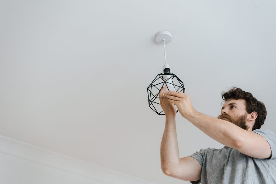 Man installing a new ceiling light fixture