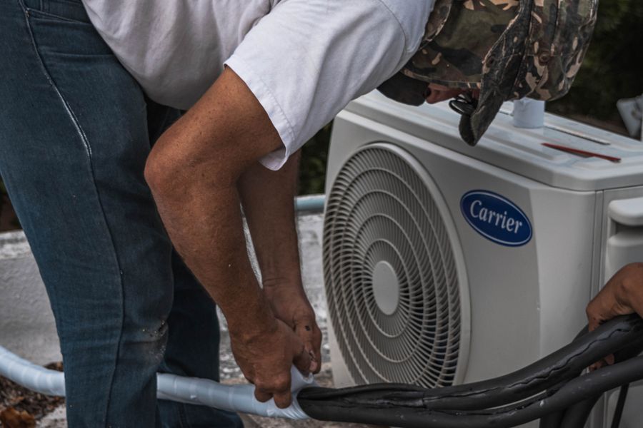 Installers connecting line sets on a new Carrier condenser unit