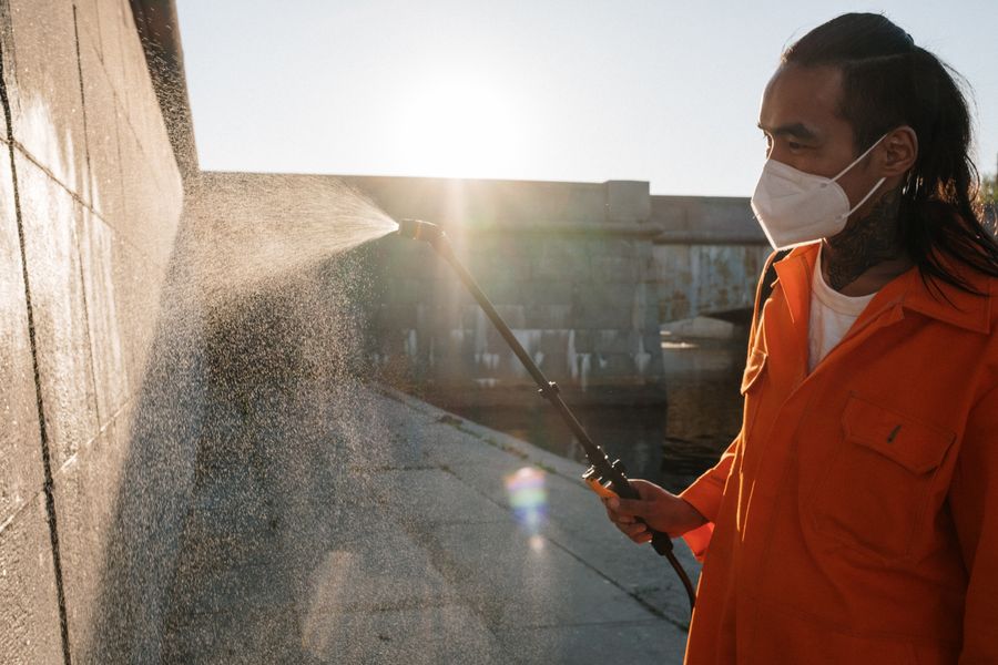 Technician spraying exterior pest treatment