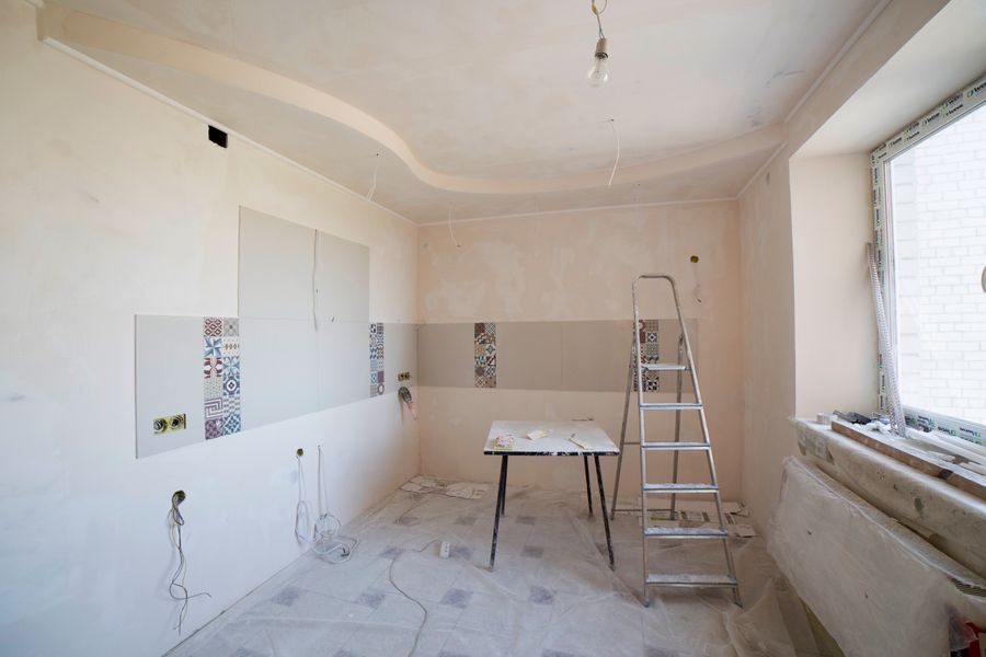 Interior room mid-renovation with ladder and prepped walls