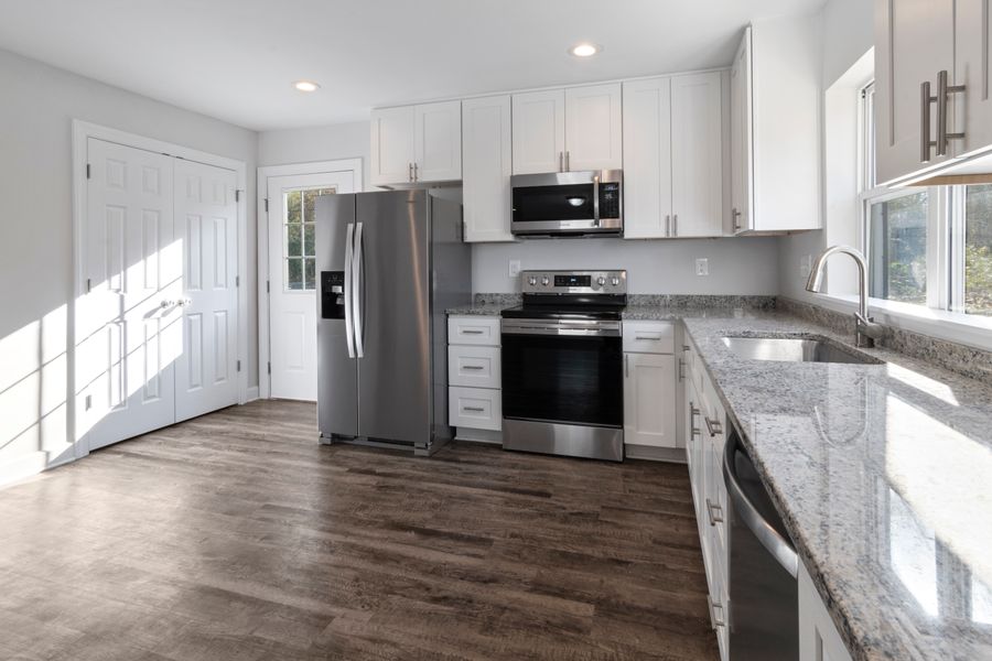 Finished kitchen remodel with granite counters, new appliances and plank flooring