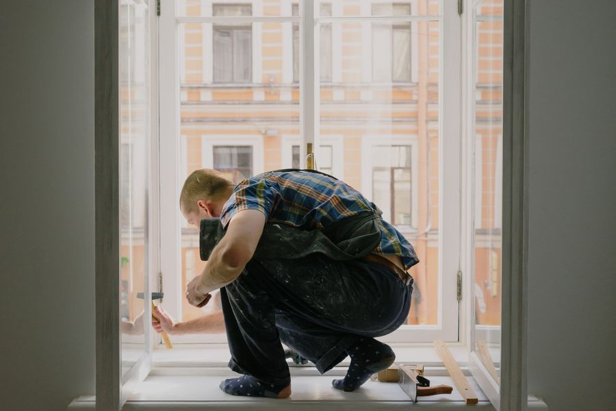 Installer finishing trim work on a newly installed window